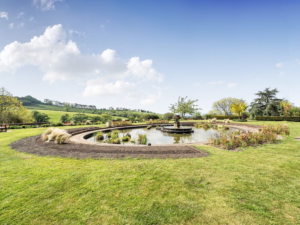 A garden with a circular pond and a fountain at Harcombe House Rooms - First Floor Single, Chudleigh