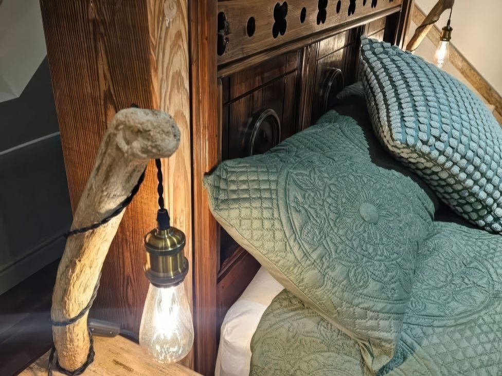 A bedroom with a bed, pillows, and a lamp at Driftwood in Bridlington