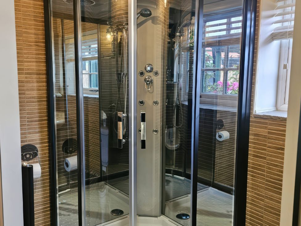 A shower unit with controls and towel holder at Driftwood in Bridlington