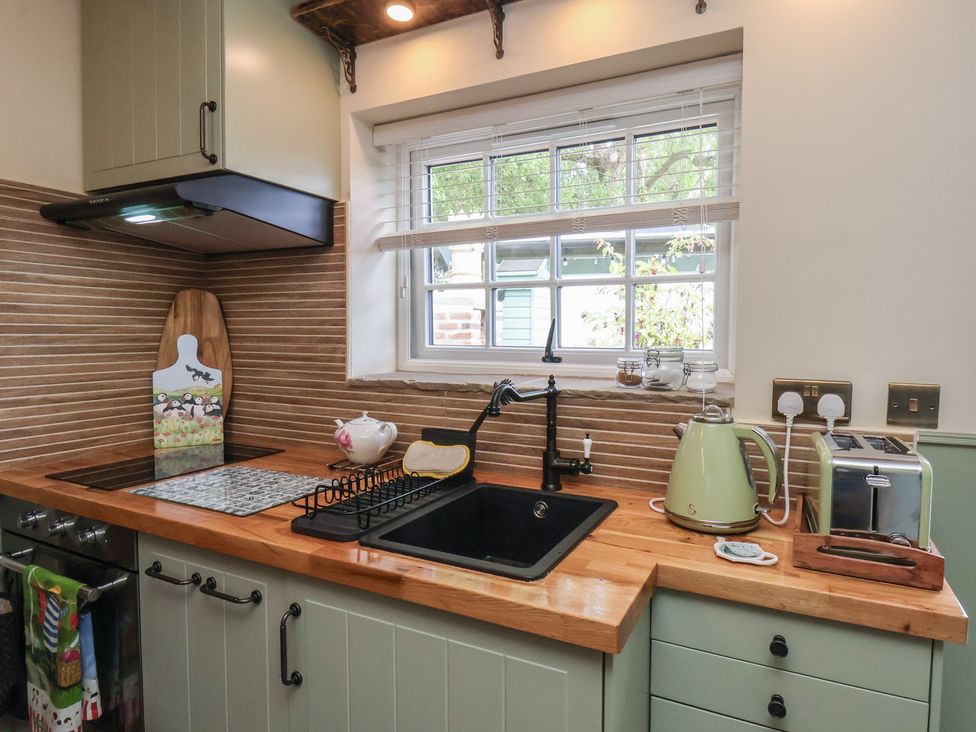 A kitchen with a sink and appliances at Driftwood in Flamborough