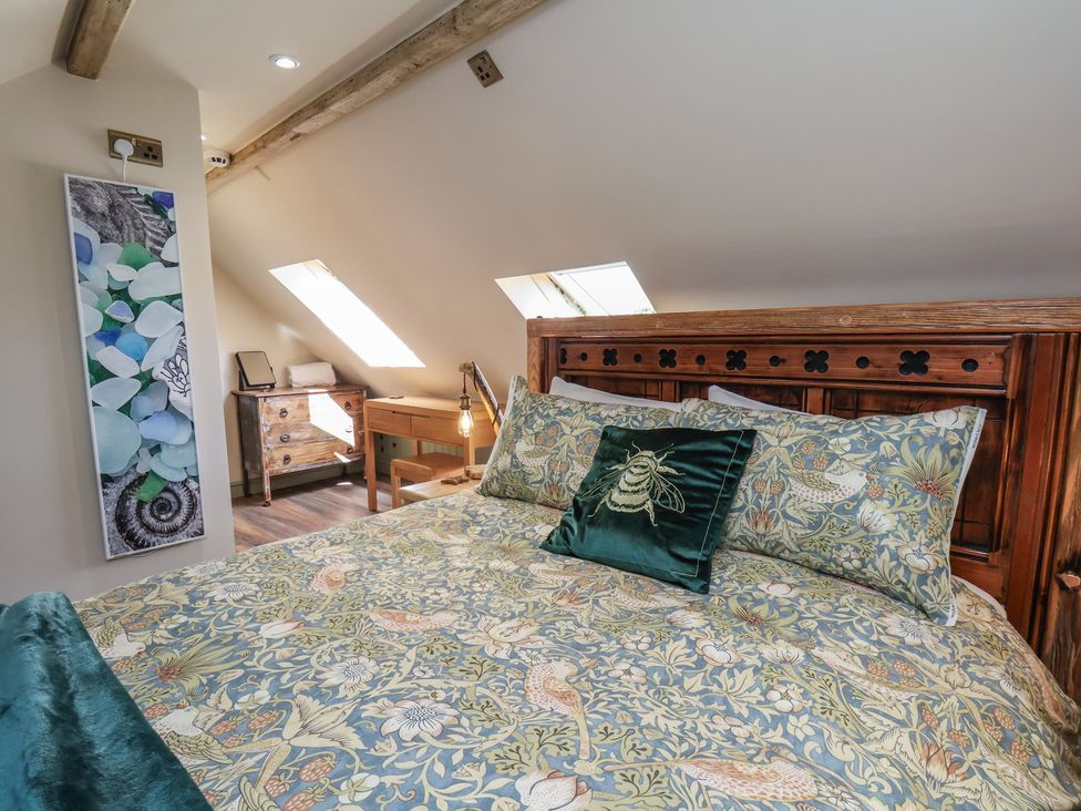 A bedroom with a bed and desk at Driftwood in Flamborough
