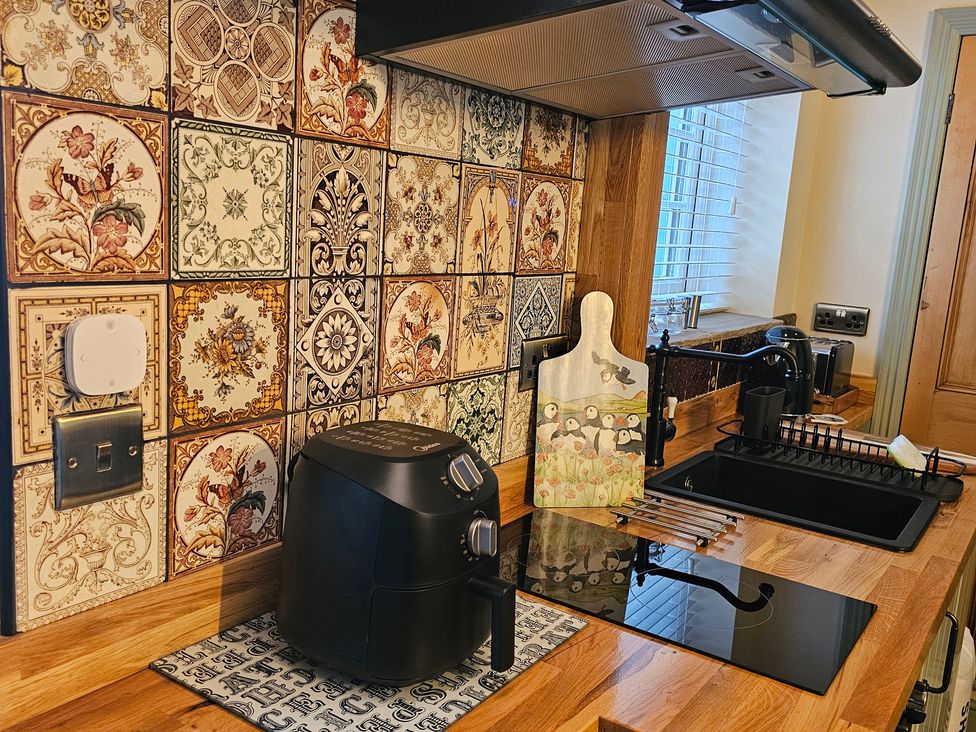 A kitchen with an air fryer and cutting board at Seaglass in Flamborough