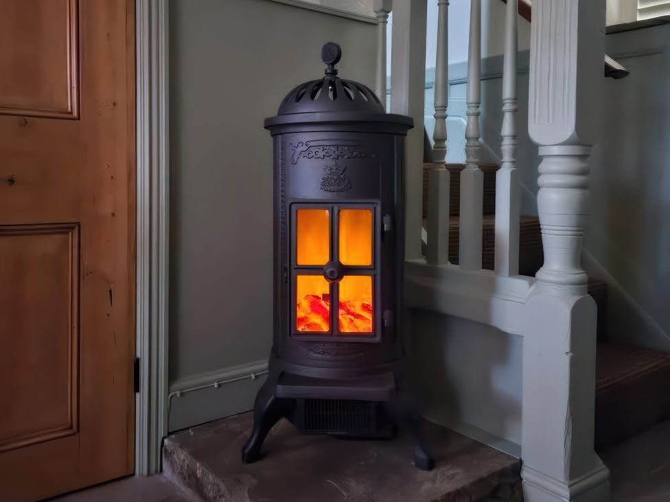 A stove in a hallway next to stairs at Seaglass in Flamborough