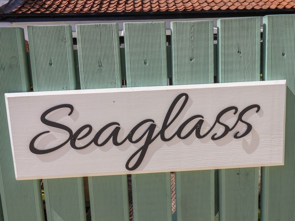A sign reading Seaglass on a wooden fence at Seaglass in Flamborough
