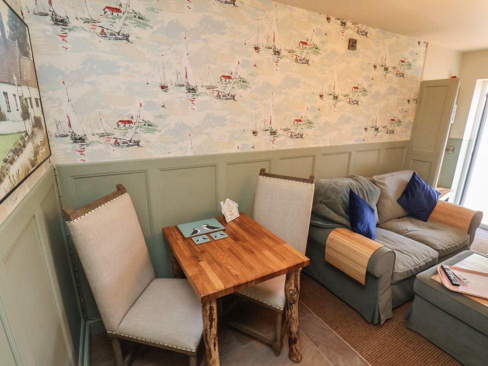 A living room with a table and chairs at Seaglass in Flamborough