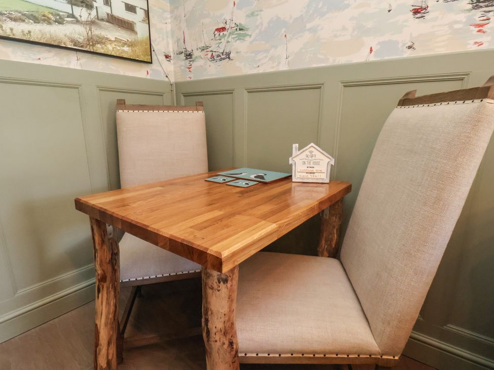 A dining room with a wooden table and chairs at Seaglass in Flamborough