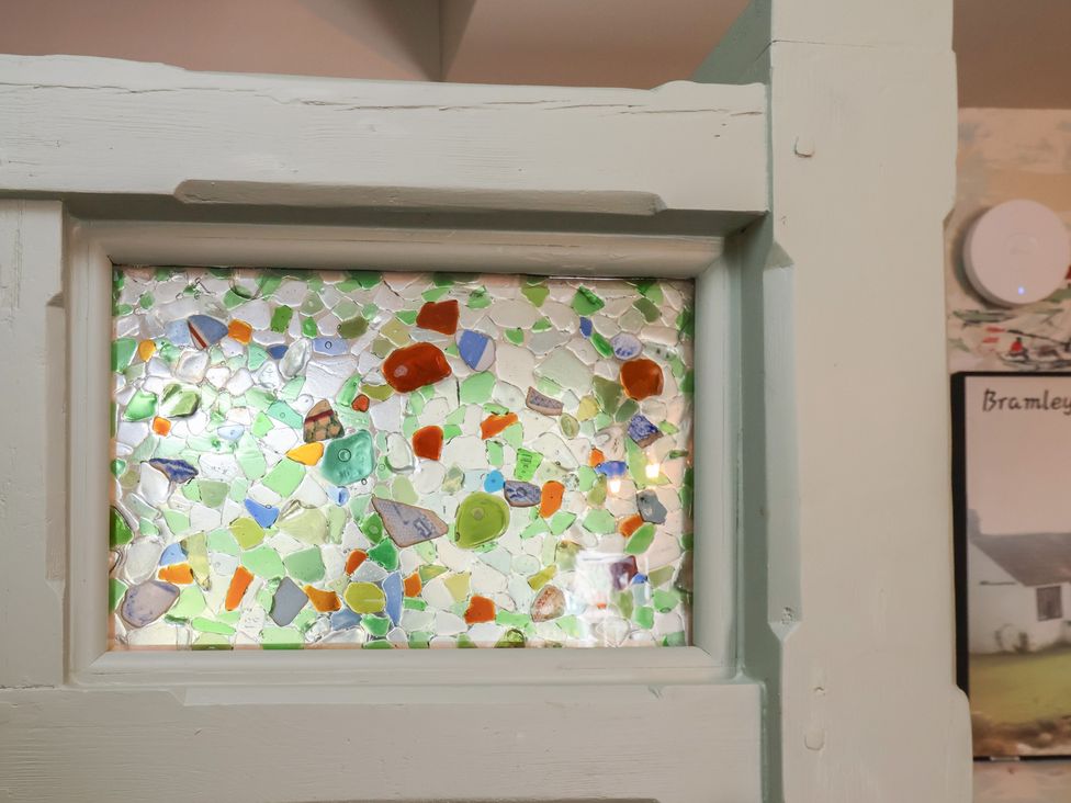 A decorative glass piece embedded in a frame at Seaglass in Flamborough