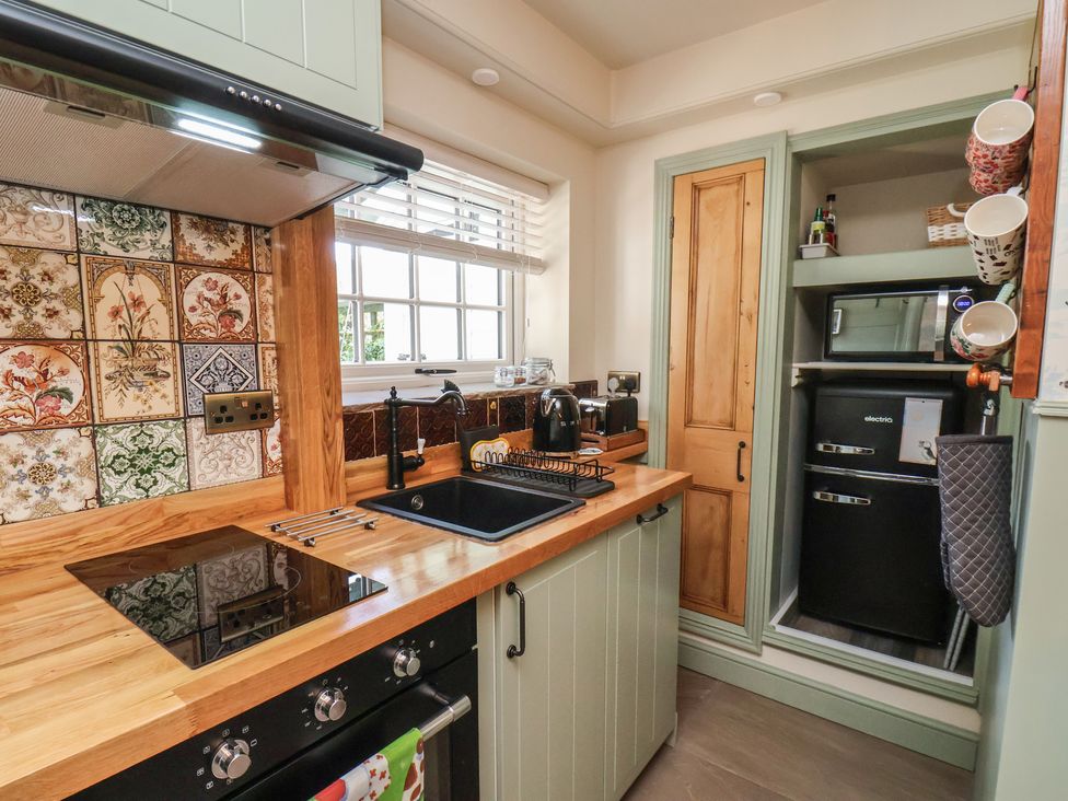 A kitchen with a sink, cooker, and refrigerator at Seaglass in Flamborough