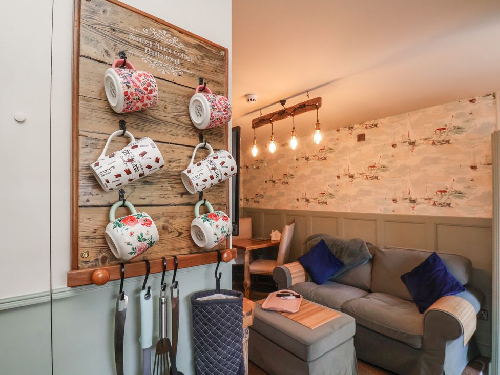 A kitchen with mugs on a wall rack at Blantyre Manor Cottage in Flamborough