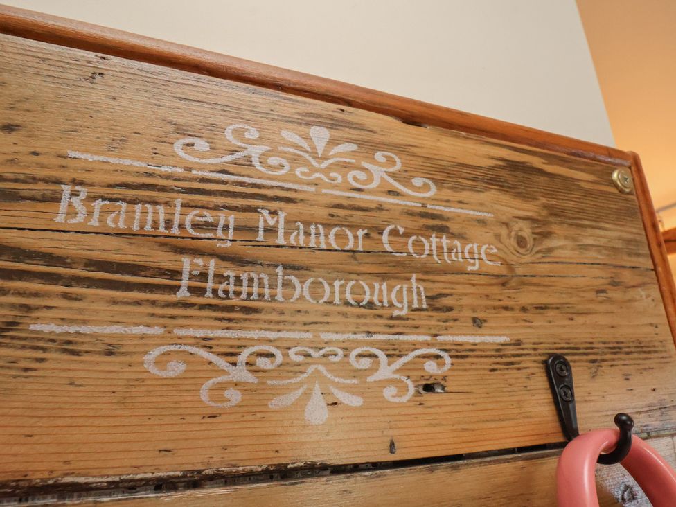 A wooden sign displaying the name Bramley Manor Cottage in Flamborough