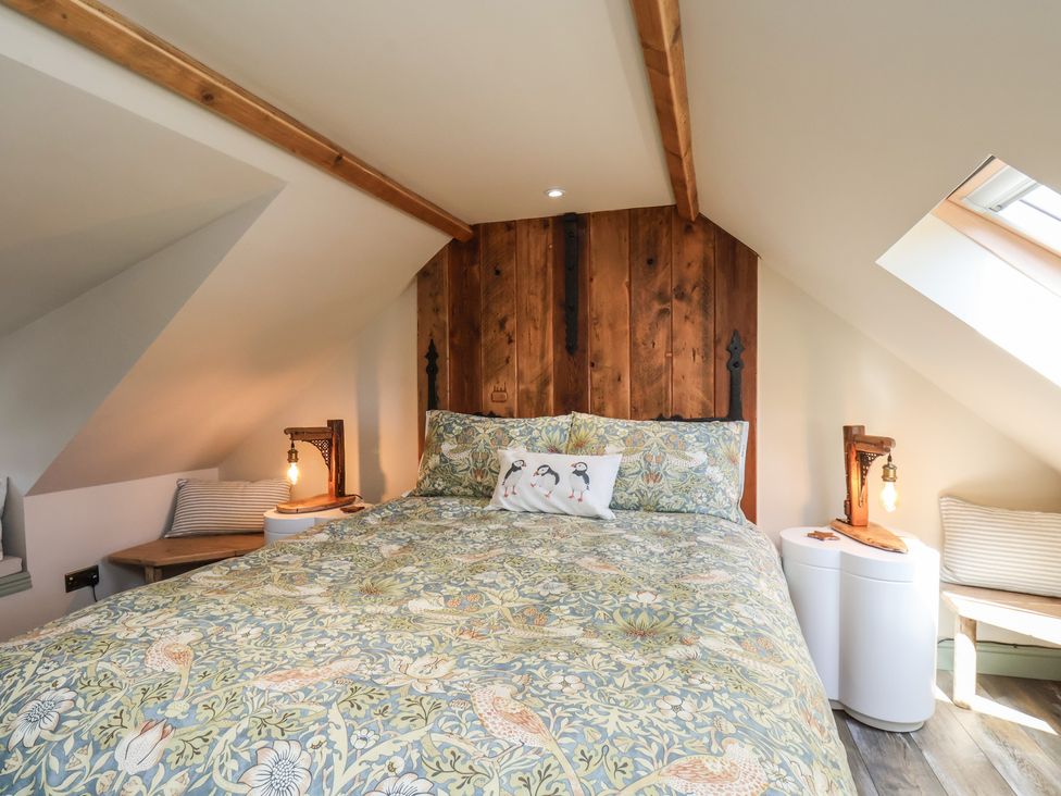A bedroom with a bed and nightstands at Seaglass in Flamborough