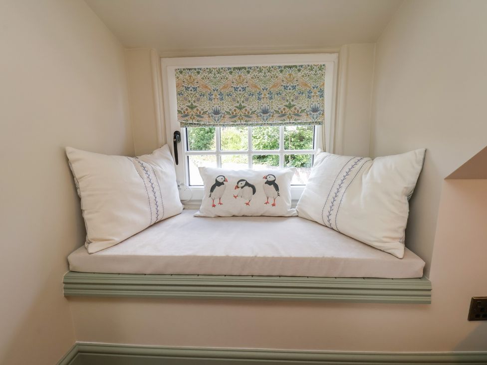 A nook with a window seat and cushions at Seaglass in Flamborough