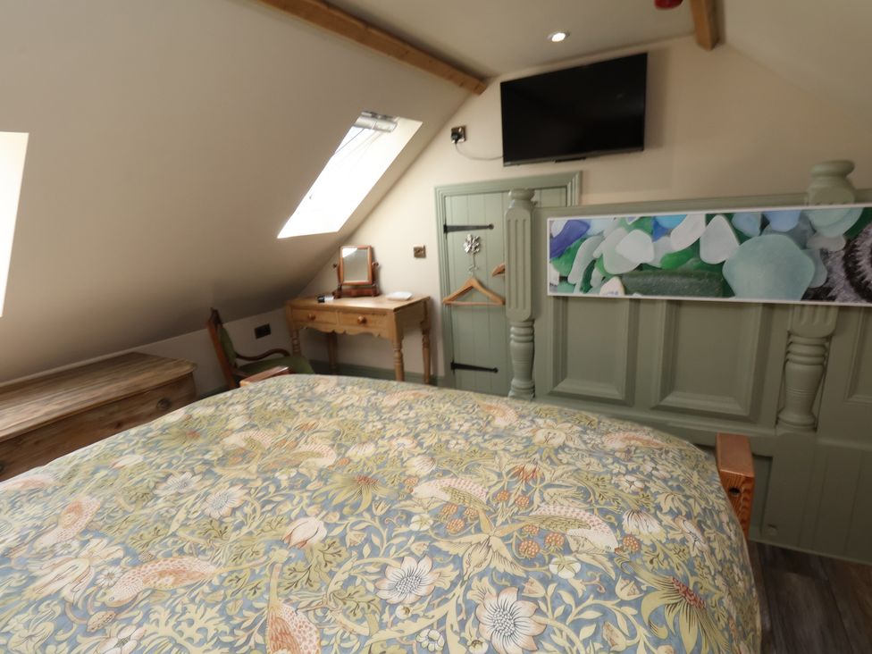 A bedroom with a bed and television at Seaglass in Flamborough