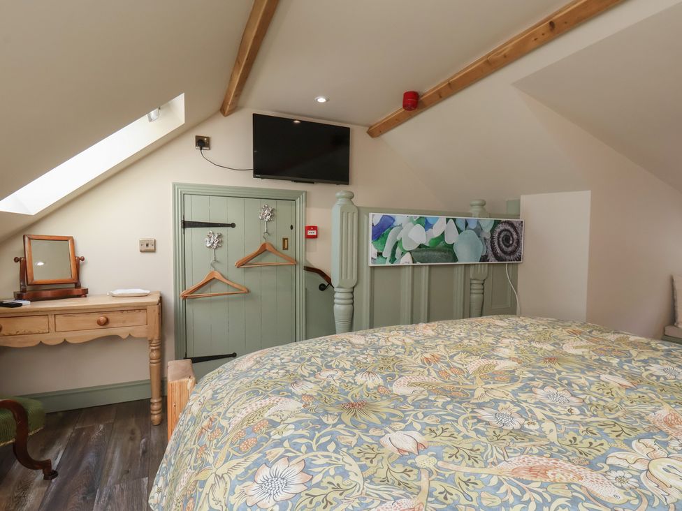 A bedroom with a bed and a television at Seaglass in Flamborough