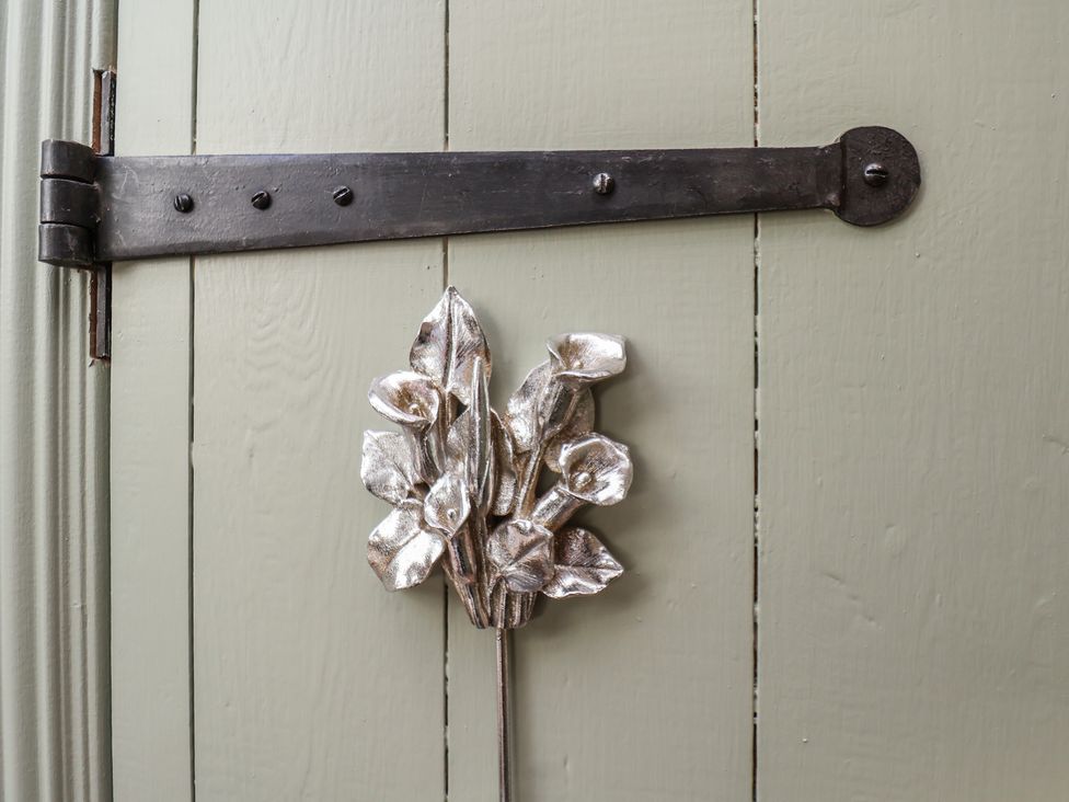 A metal hinge and decorative flower on a door at Seaglass in Flamborough