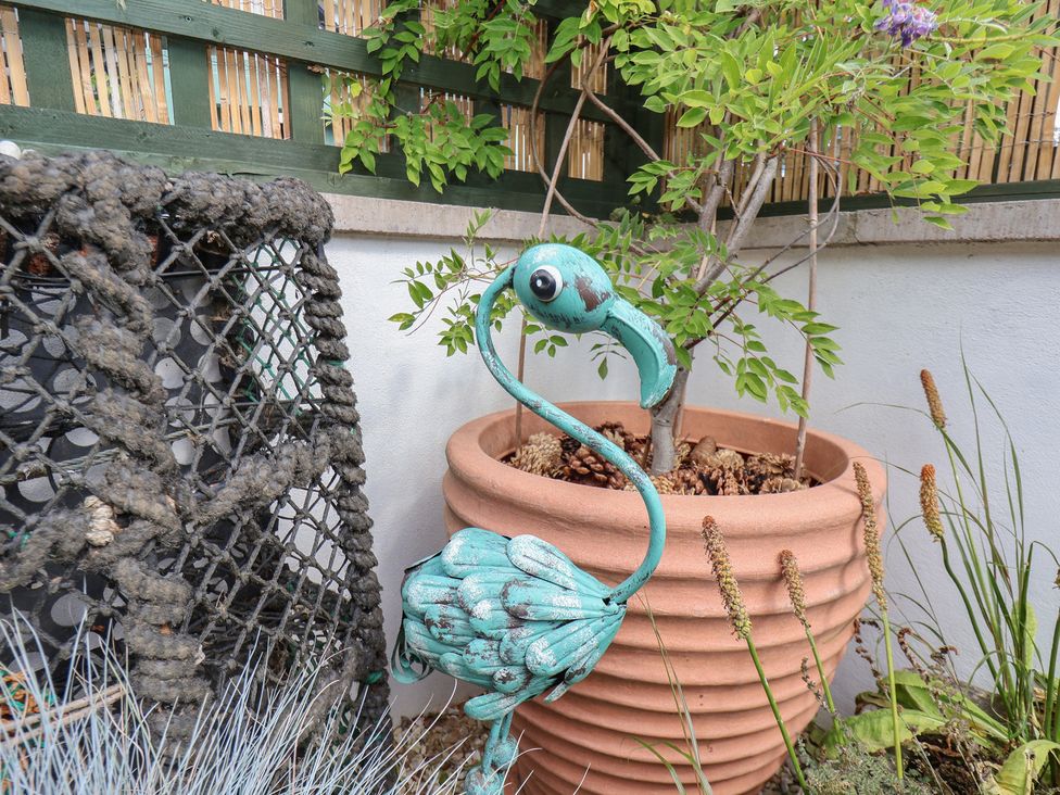 A garden with a flamingo statue and a plant pot at Seaglass in Flamborough