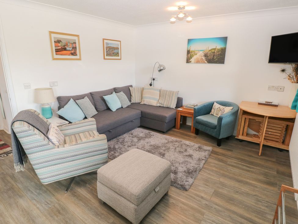 A living room with seating and decor at Puffin Nook in Broad Haven