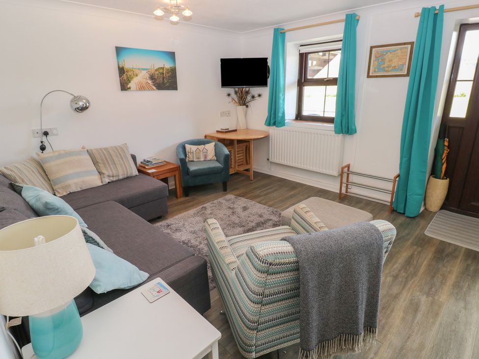 A living room with a sofa and television at Puffin Nook in Broad Haven