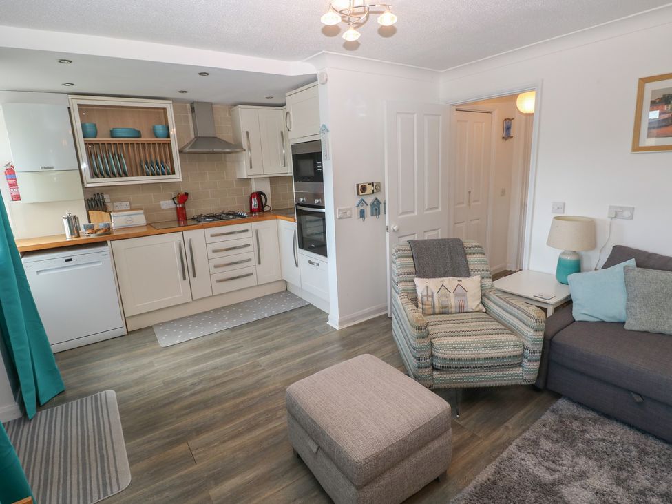 A kitchen and living room area with furniture at Puffin Nook Broad Haven