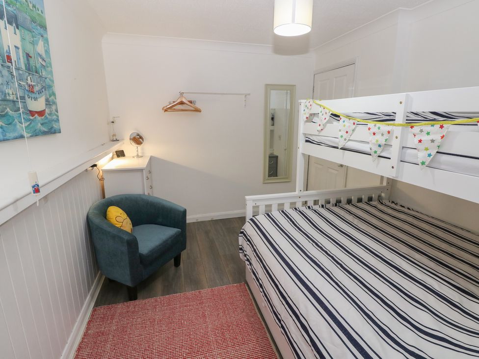 A bedroom featuring a bunk bed and a desk at Puffin Nook in Broad Haven