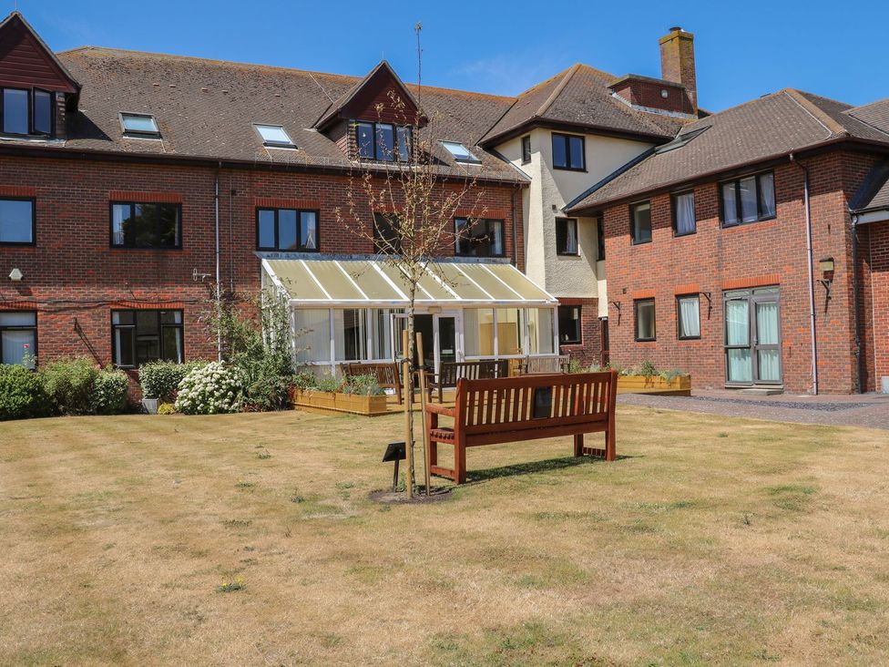 An outdoor area with a bench and buildings at Pebble Path in Littlehampton