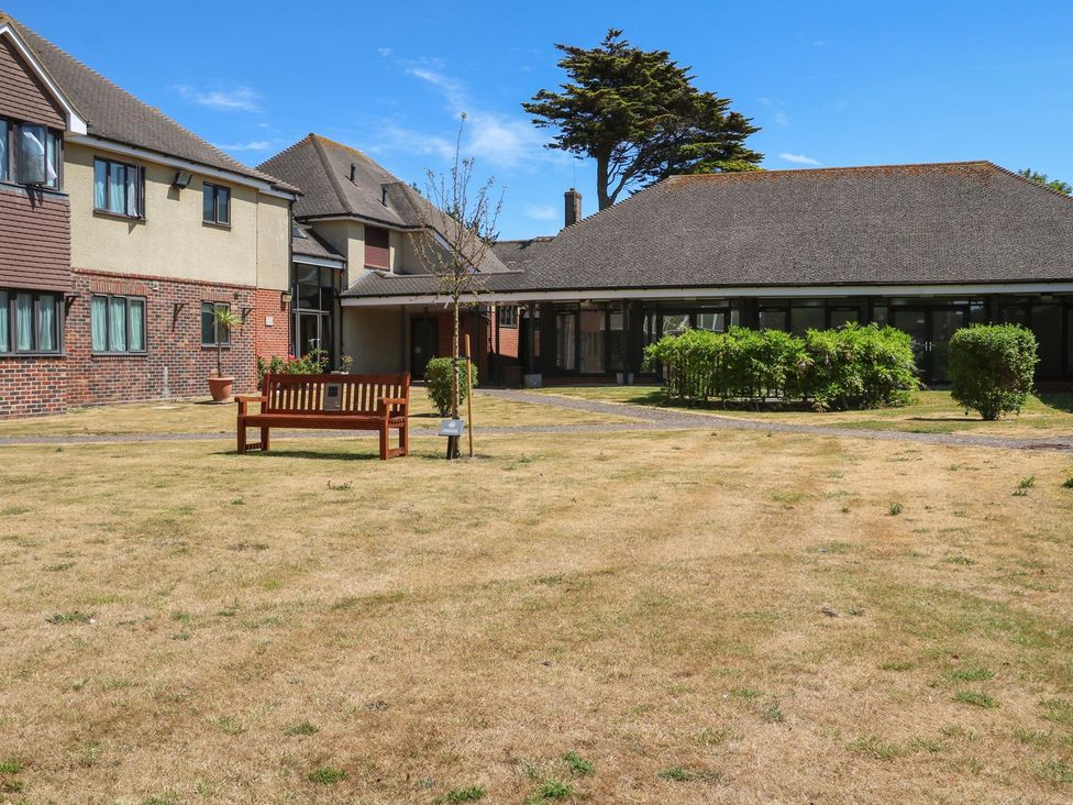A garden with a bench and buildings at Pebble Path in Littlehampton