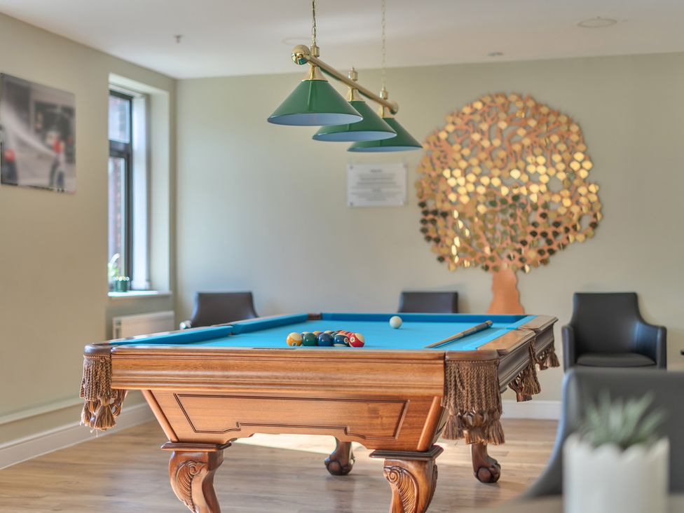 A pool table with balls and chairs at Marine Court Suite in Littlehampton