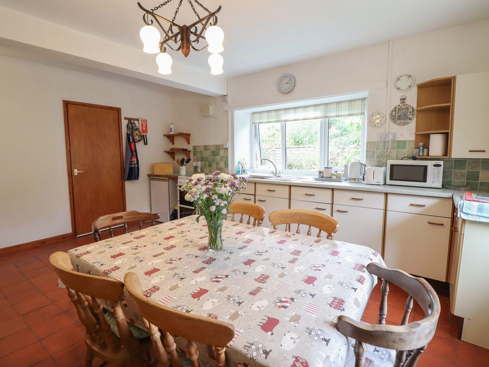 A kitchen with a dining table and microwave at Hafod in Llangollen