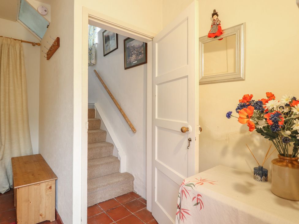 A hallway with a staircase and decorative arrangements at Hafod in Llangollen