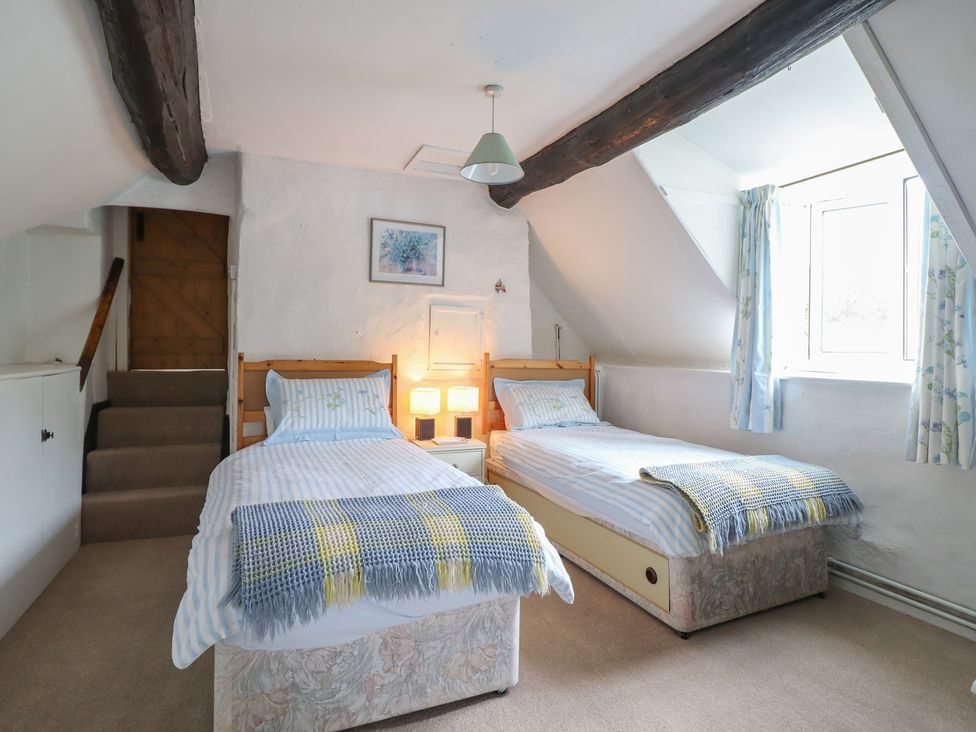 A bedroom with twin beds and a staircase at Hafod in Llangollen