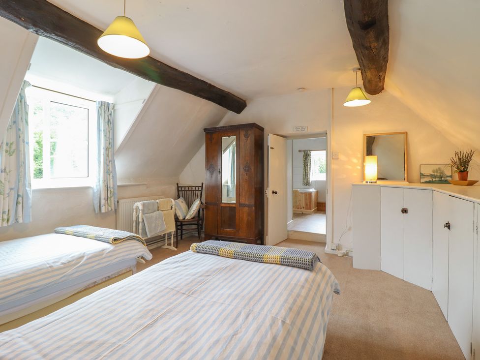 A bedroom with two beds and a wardrobe at Hafod in Llangollen