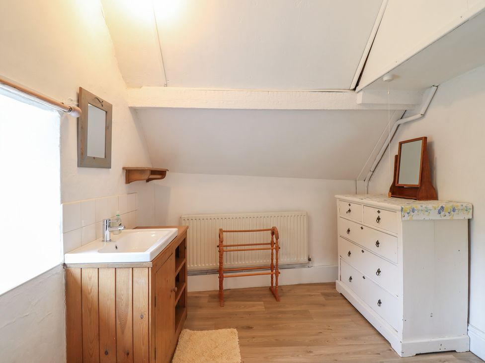 A bathroom with a sink and wooden furniture at Hafod in Llangollen