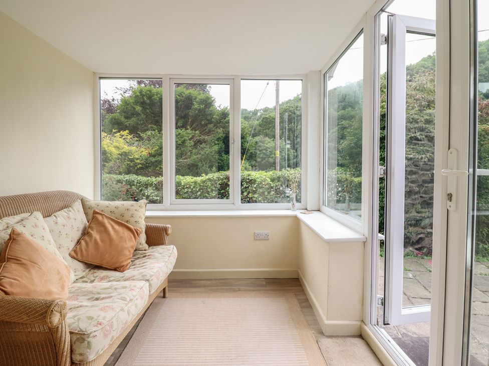 A conservatory with a sofa near windows at Hafod in Llangollen