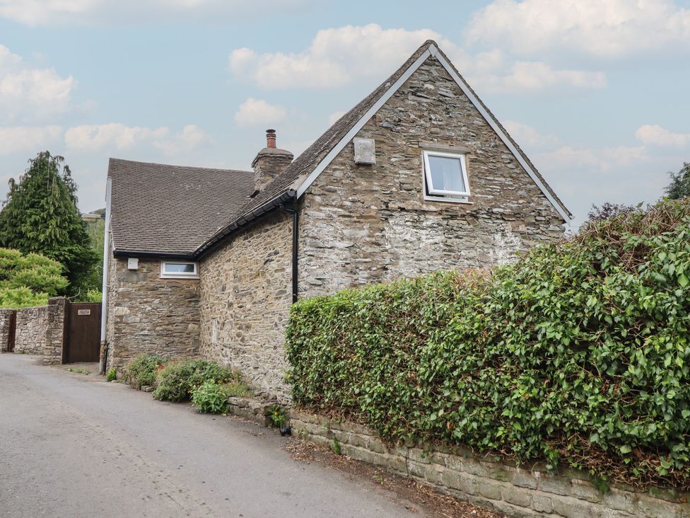 A house with stone exterior and hedge at Hafod, Llangollen