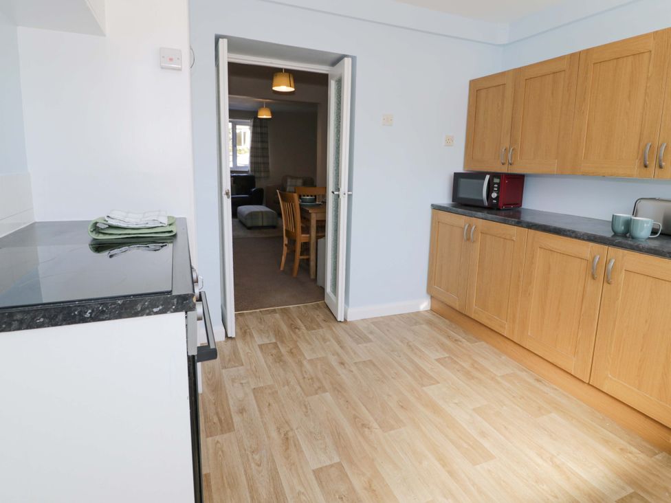 A kitchen with cabinets and a microwave at Bryn Hyfryd in Conwy