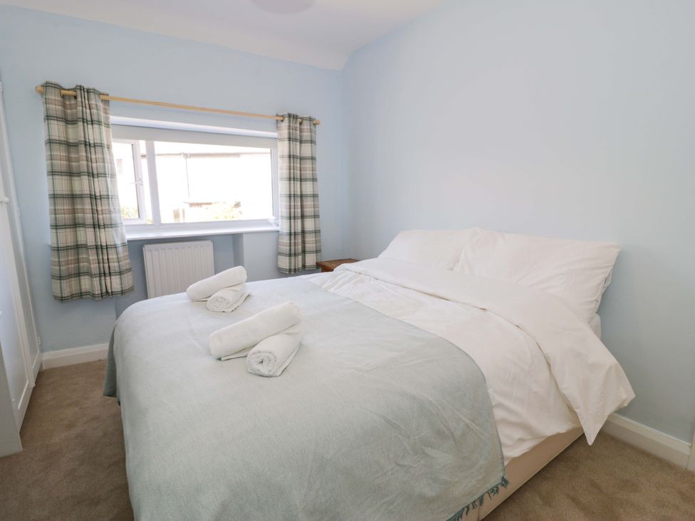 A bedroom with a bed and window at Bryn Hyfryd in Conwy