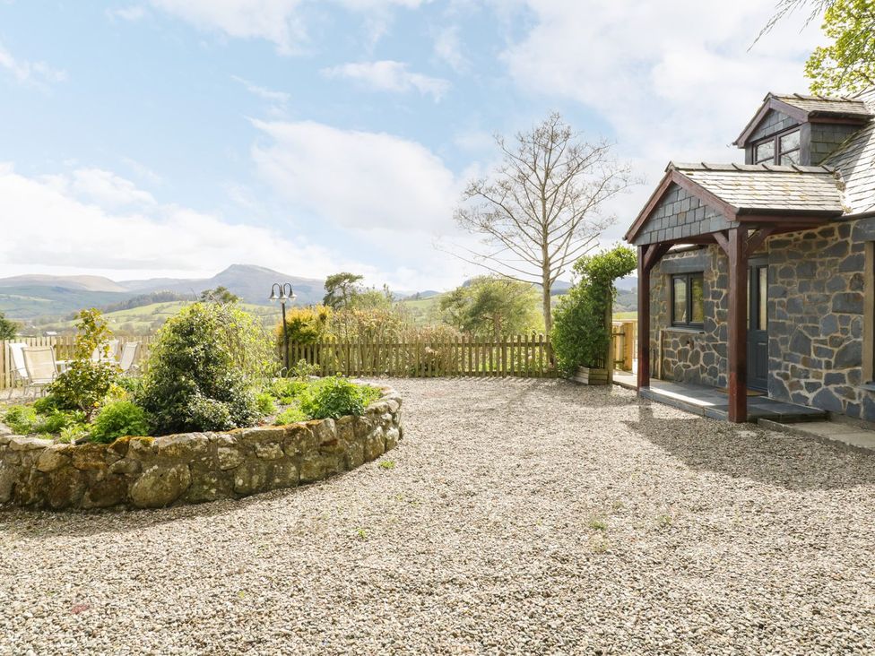 An outdoor view of a house with garden and gravel area at Cyffdy Cottage - Aran Bala