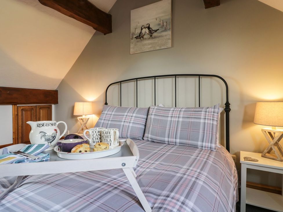 A bedroom with a bed and a tray with tea and cookies at Cyffdy Cottage - Aran Bala