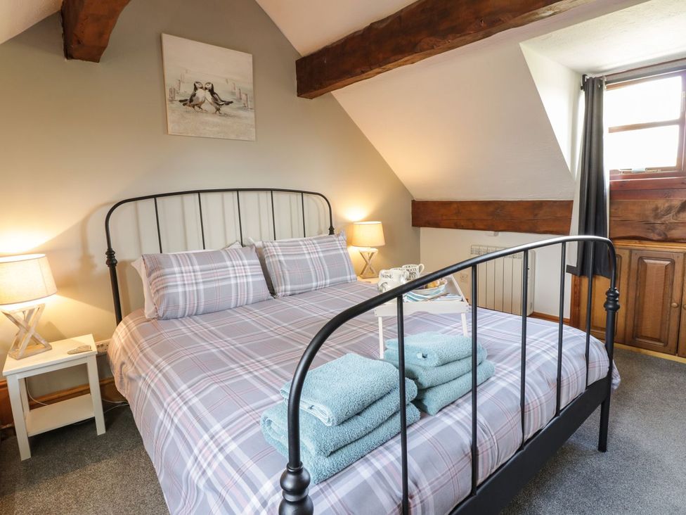A bedroom with a bed, towels, and a window at Cyffdy Cottage - Aran Bala