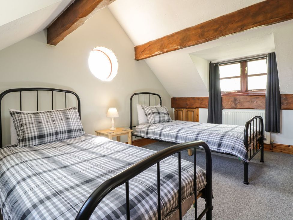 A bedroom with two beds and a lamp at Cyffdy Cottage - Aran in Bala