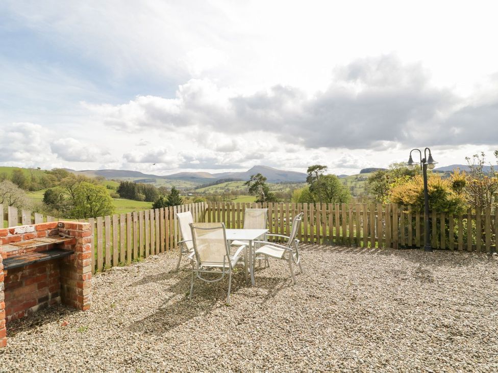 A garden with a table and chairs at Cyffdy Cottage - Aran Bala