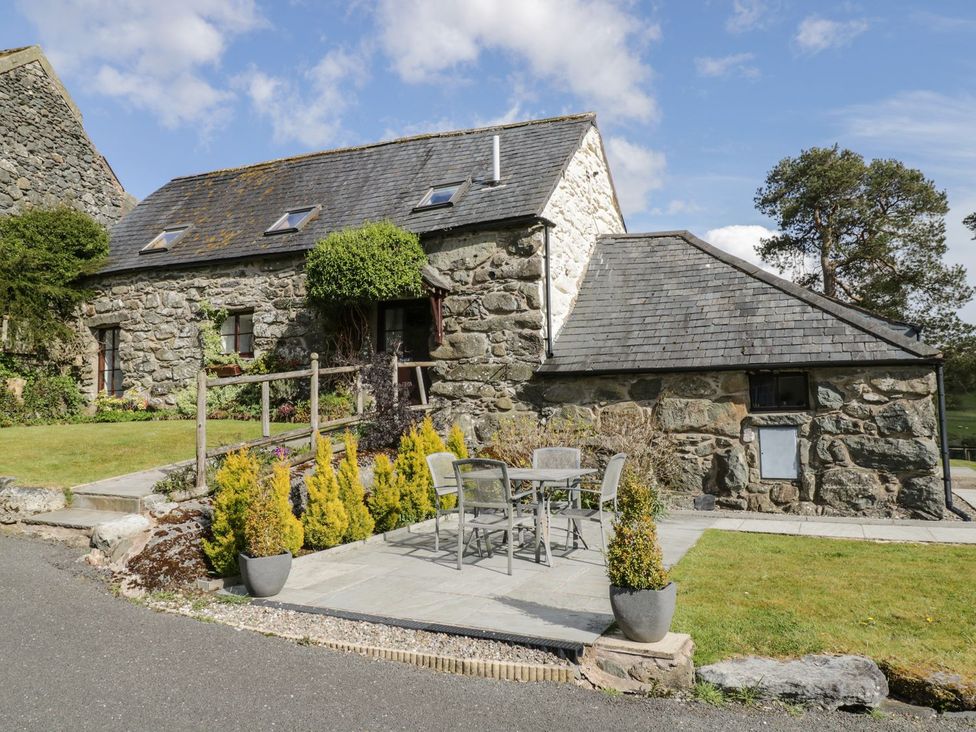 A stone house with a patio area and garden at Cyffdy Cottage - Tegid in Bala