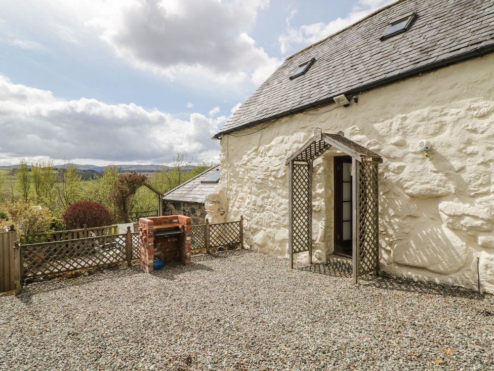 An outdoor area with a barbecue and trellis at Cyffdy Cottage - Tegid, Bala