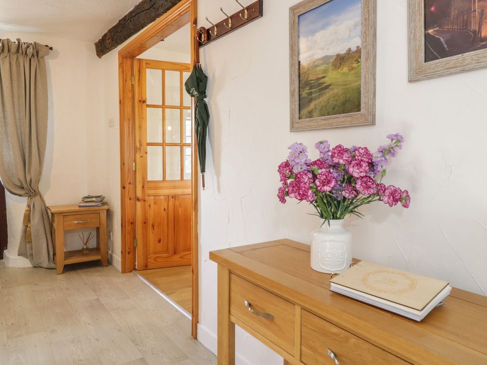 A hallway with a table and flower vase at Cyffdy Cottage - Tegid in Bala