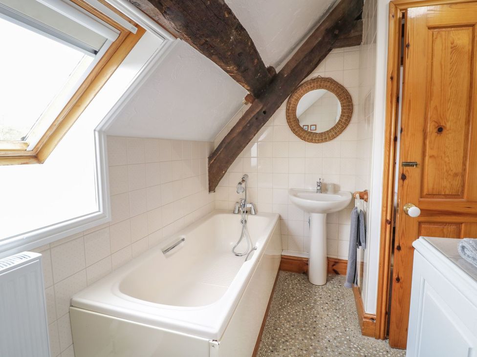 A bathroom with a bath tub and sink at Cyffdy Cottage - Tegid in Bala