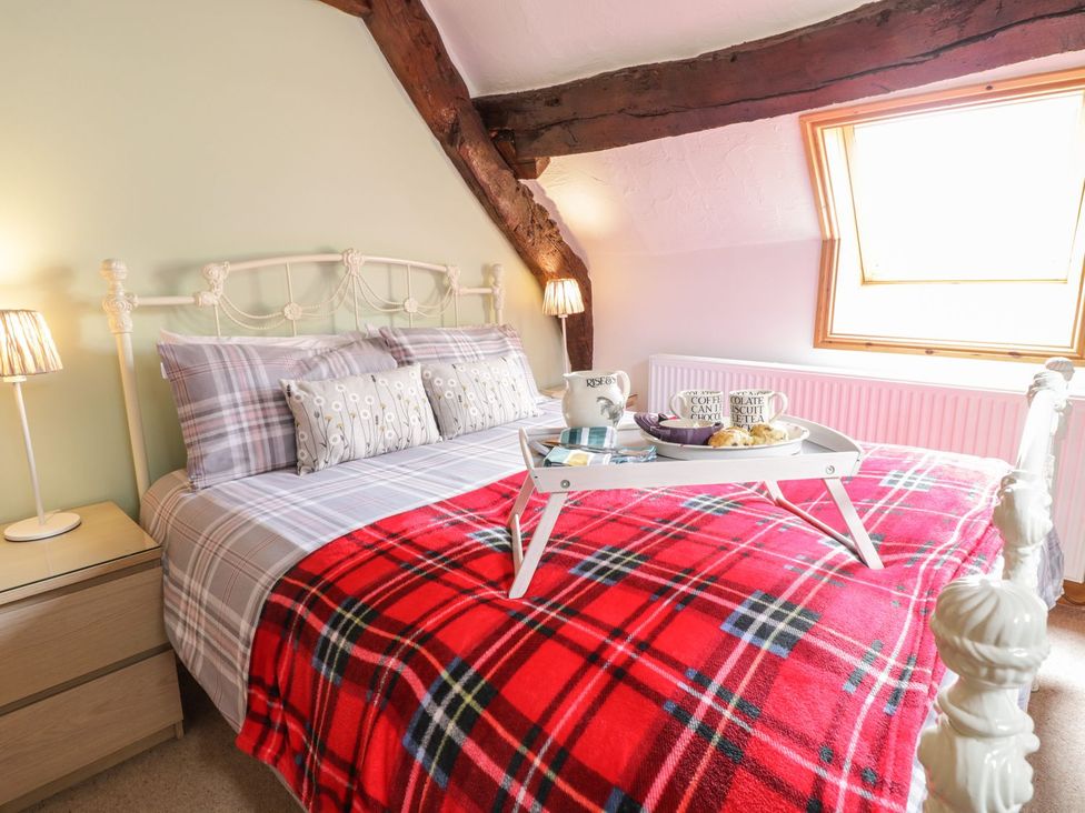 A bedroom with a bed and tray on the covers at Cyffdy Cottage - Tegid Bala