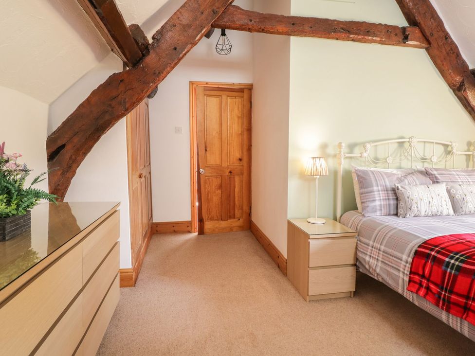 A bedroom with a bed and bedside table at Cyffdy Cottage - Tegid in Bala