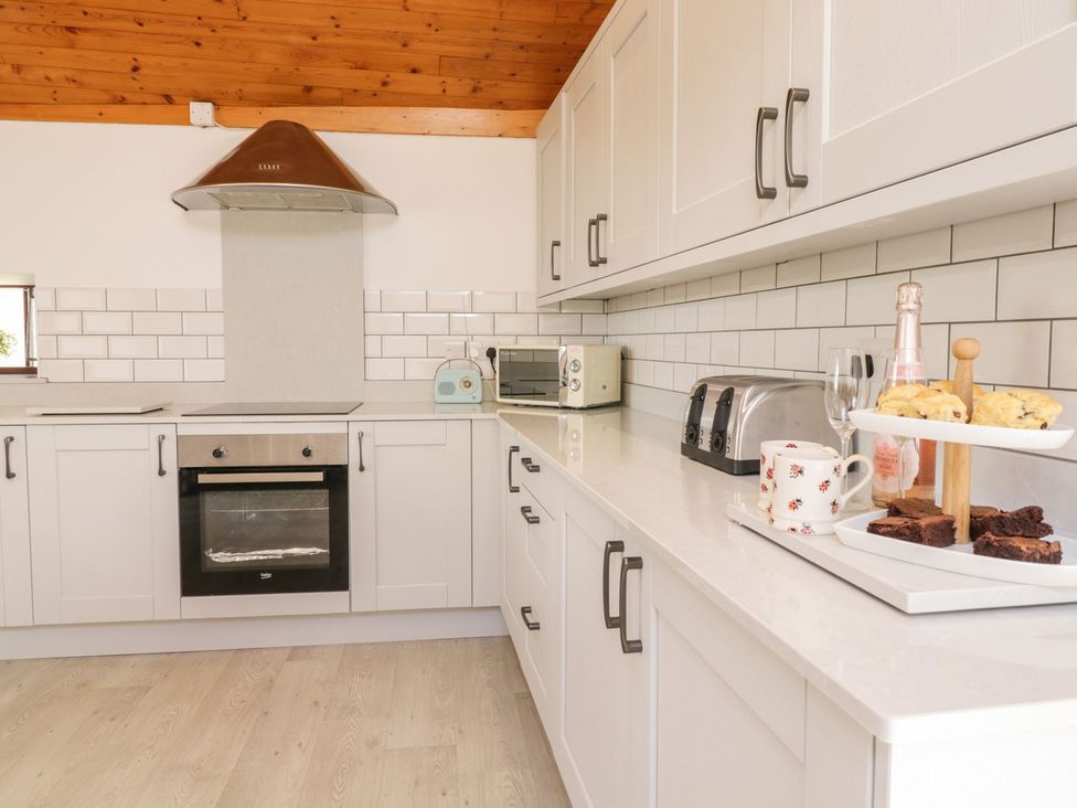 A kitchen with an oven, toaster, and snacks at Cyffdy Cottage - Tegid in Bala
