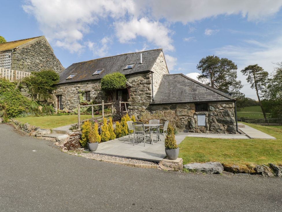 An outdoor area with a stone building and seating at Cyffdy Cottage - Tegid in Bala