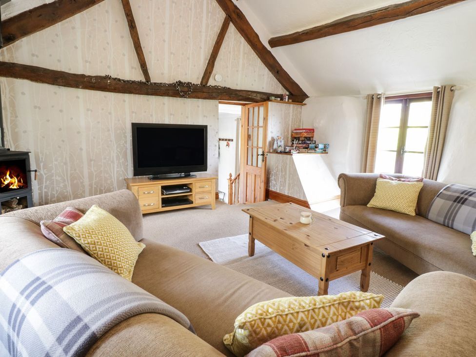 A living room with a television and seating at Cyffdy Cottage - Arenig Bala